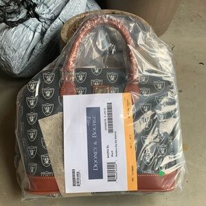 Raiders dooney & bourke purse. With label and never opened. Retail $248.00